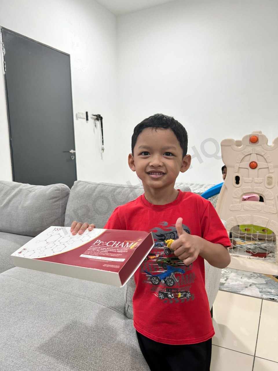 Anak buat thumbs-up memegang kotak ProCHAM Infinity